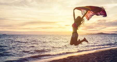 Free happy woman enjoying sunset at beach