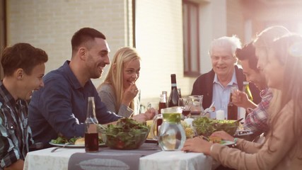 Group of Mixed Race People Having fun, Communicating and Eating at Outdoor Family Dinner - Powered by Adobe