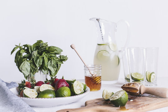 Ingredients for honey sweetened limeade with strawberries and basil