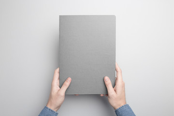 Hand is holding gray Notebook