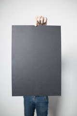 Man holding a black poster