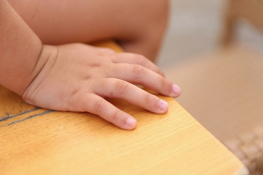 closeup of a child's hand sitting on a desk,