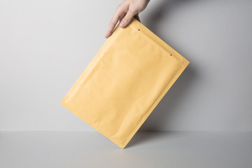 Hand holding Blank Padded Envelope Mock-up