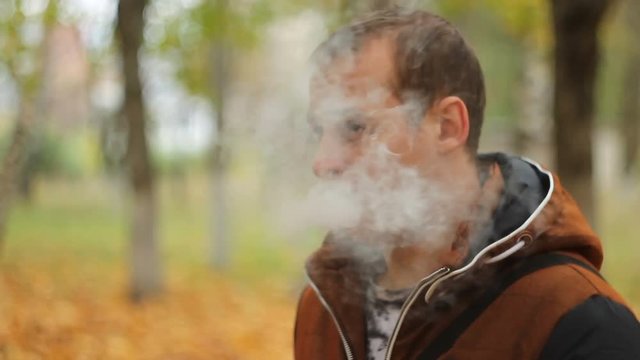 Man smoking electronic sigarette in the forest