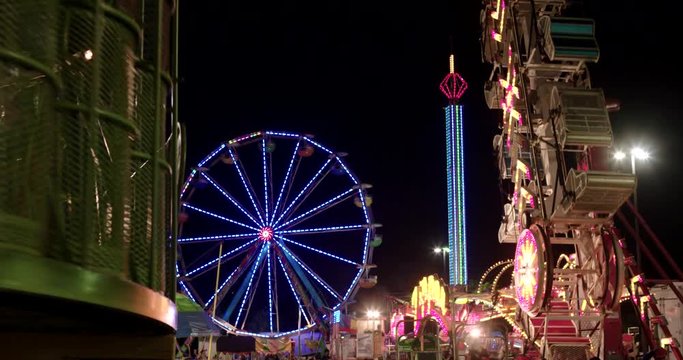 Carnival rides and ferris wheel at night