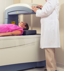 Woman in 40s undergoing open mri with doctor supervising
