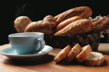 Fresh bread and wheat on the wooden with black background