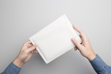 Hand holding blank padded envelope