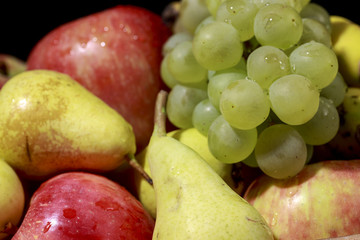 Detail of heap of fruits: pears, grapes, apples and bananas