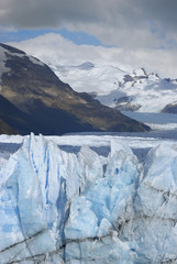 Hostile glacier peaks from Perito Moreno in front of mountain chain 