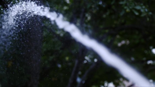 Slow motion of water being sprayed from hose