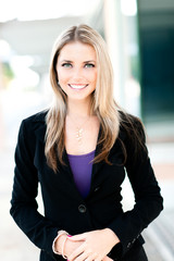 Attractive young businesswoman saleswoman reprepresentative real estate agent outdoor headshot business portrait