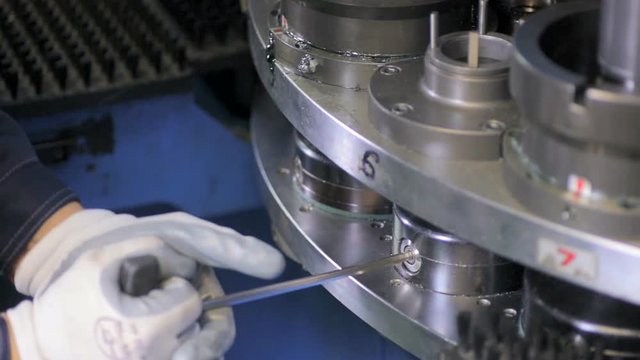 An industrial serviceman repairing, labouring at a cnc industrial machine. HD.