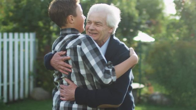 Grandson Runs Toward his Grandfather and Huggs Him