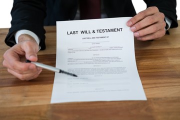 Mid section of businessman showing last will and testament form