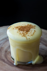 Boza or Bosa drink flows from a glass with cinnamon