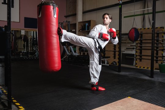 Man practicing karate with punching bag