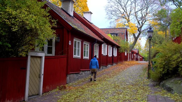 A man walking along a street lined with traditional wooden houses at Sodermalm, a part of central Stockholm.