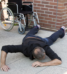 impaired man on the floor after falling out of wheelchair