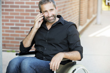 man in wheelchair talking on his phone