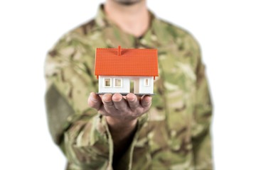 Mid section of soldier holding a model home