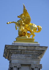 Fototapeta na wymiar The golden statues on Alexandre III bridge in Paris