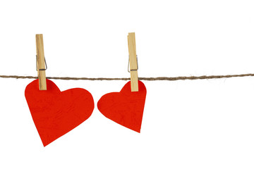 Red heart hanging on clothesline on white background