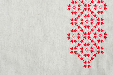 Embroidery design by red and white cotton threads on flax. Christmas background with embroidery.