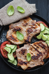 Roasted pork chop steaks with fresh vegetables, close-up