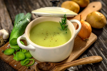 Homemade creamy leek soup on wooden background