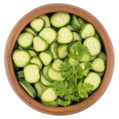  Fresh slice cucumber in wood bowl on white background