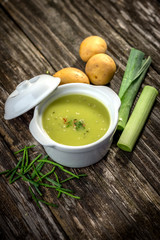 Homemade creamy leek soup on wooden background