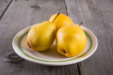 Fresh ripe organic yello pears on rustic wooden table, natural background, diet food.