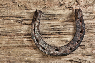 old rusty horseshoe on a wood background