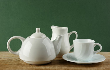 white ceramic coffee set on old wooden table over green backgrou