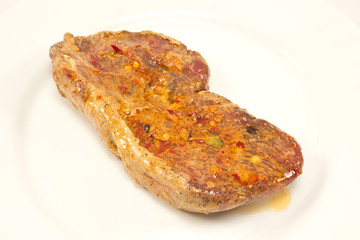 Raw beef steak with marinade in white plate