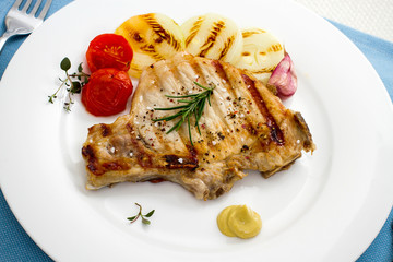 Juicy grilled pork chop with onion rings