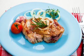 Juicy grilled pork chop with onion rings