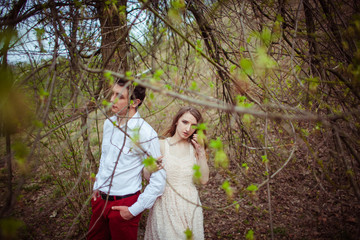 Look through the green spring leaves at stunning couple standing