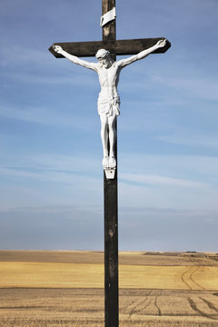 Crucifix and a farm field in the background;Saskatchewan canada