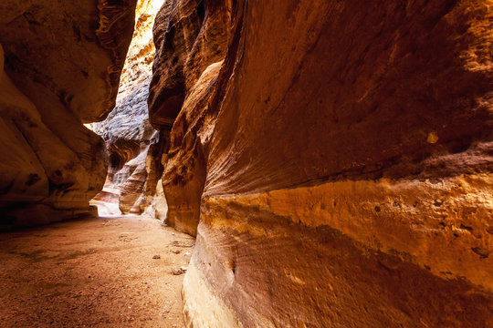 High rock walls and a narrow path at the entrance to an ancient city;Petra jordan