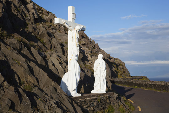 Statue of jesus christ on the cross with two women at the foot of the cross on the side of the road;County kerry, ireland
