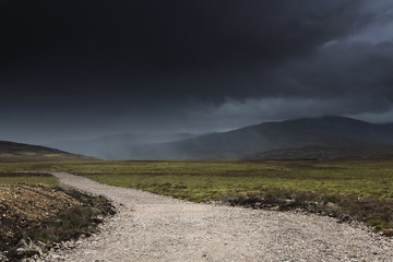 A gravel path under dark storm clouds;Highlands scotland