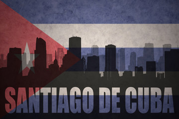 abstract silhouette of the city with text Santiago de Cuba at the vintage cuban flag