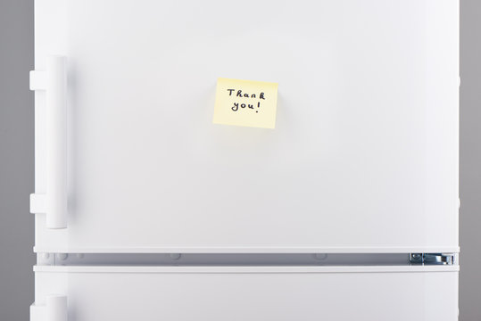 Thank you note on yellow sticky paper on white refrigerator