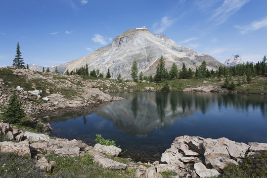 Mountain reflecting on mountain lake with blue sky and clouds;Field british columbia canada