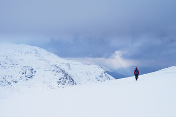 Woman walking in snow covered, winter conditions on Beinn an Dothaidh, near Bridge of Orchy; Argyll and Bute, Scotland