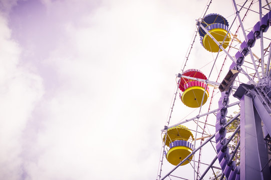 Vintage ferris wheel on the blue sky with clouds