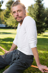 Naklejka na ściany i meble Portrait of man sitting on slackline and resting