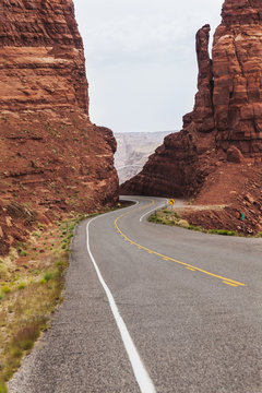 Highway 95 West Of Hite, Utah As The Road Drops Down Between Two Red Sandstone Formations To The Colorado River; Utah, United States Of America